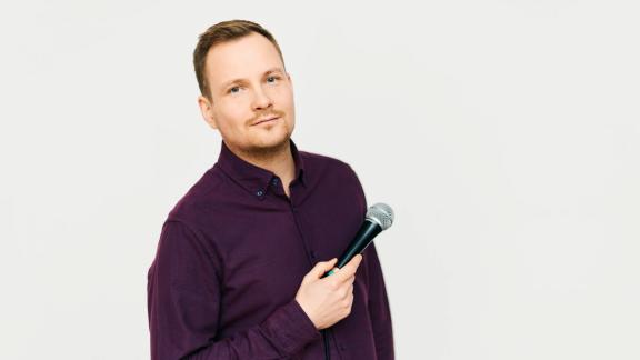 Der Künstler Jakob Schwerdtfeger mit einem Mikrofon in der Hand.